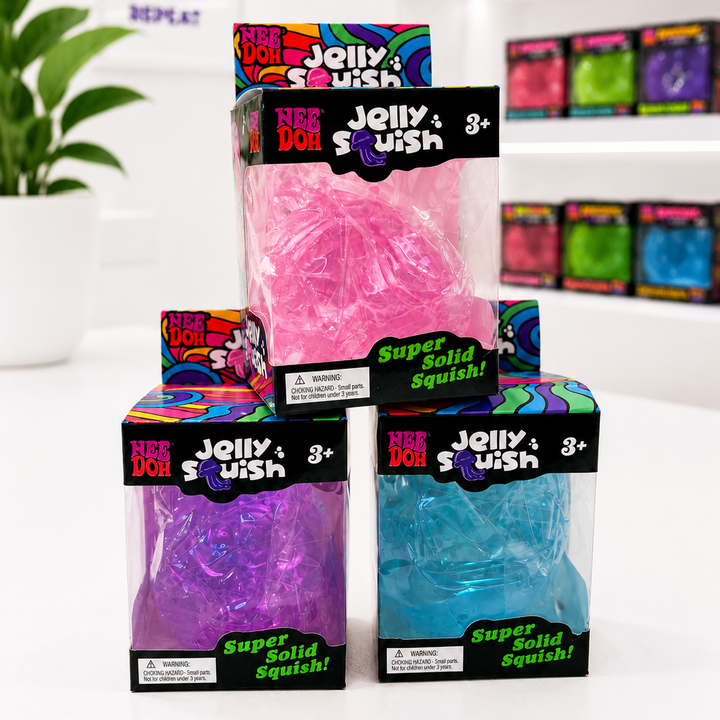 Packaged jelly squish toys in pink, purple, and blue with colorful packaging on a white surface.
