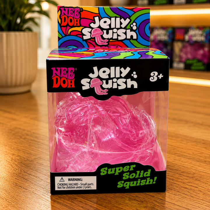 Pink jelly squish toy in a colorful packaging on a wooden surface